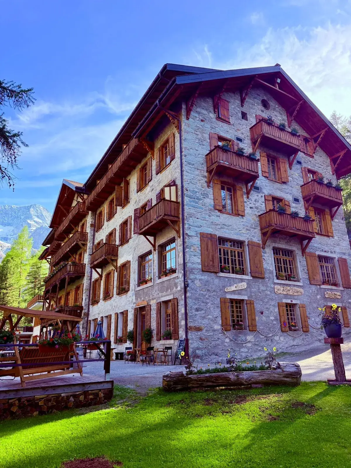 Façade en pierre du Grand Hôtel & Kurhaus en été, balcons de bois fleuris — Arolla, Val d'Hérens