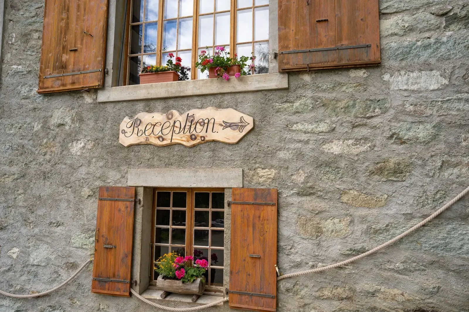 Panneau « Réception » peint à la main sur la façade en pierre du Grand Hôtel & Kurhaus — Arolla